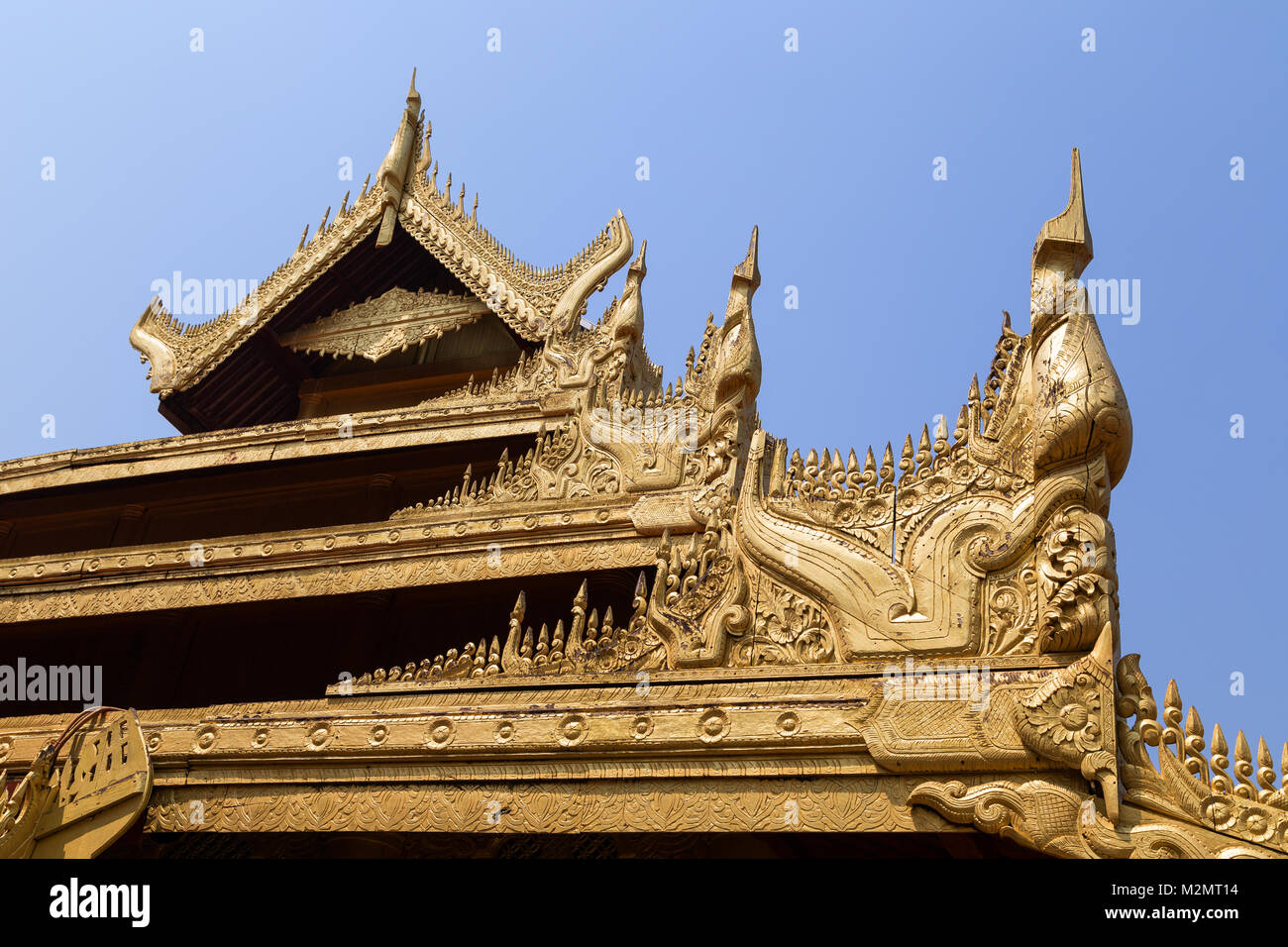 Décorations d'un toit de couleur or ornée et d'un bâtiment au royal palais de Mandalay à Mandalay, Myanmar (Birmanie) sur une journée ensoleillée. Banque D'Images