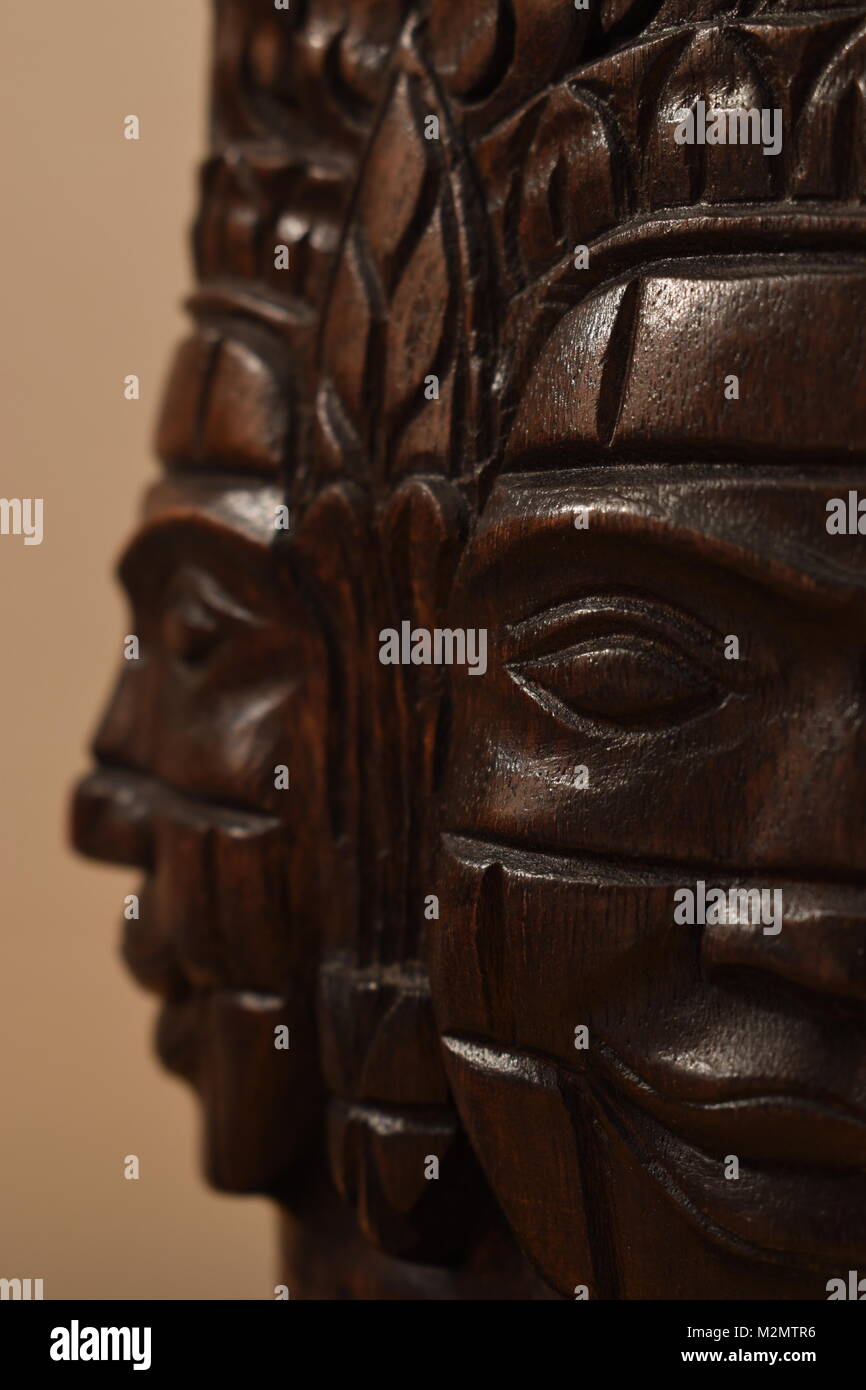 Libre d'un masque en bois sculpture du Cambodge, montrant deux visages à la perpendiculaire à l'autre avec l'avant face à la sculpture en focus. Banque D'Images