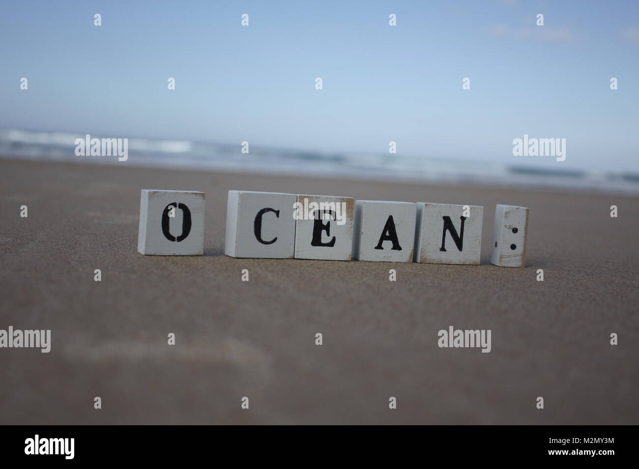 Lettres en bois debout devant l'Océan Banque D'Images