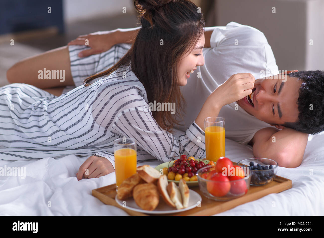 Les jeunes couples ont un petit déjeuner au lit Banque D'Images