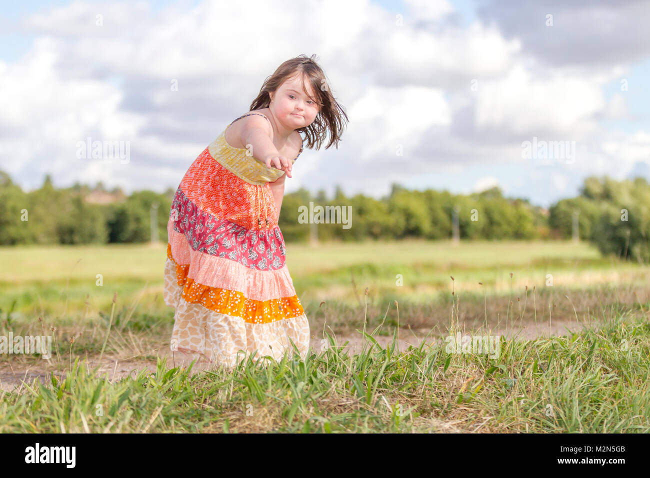 Jeune fille avec le syndrome de Down profitant de l'ensoleillement du matin avec grandparants. Banque D'Images