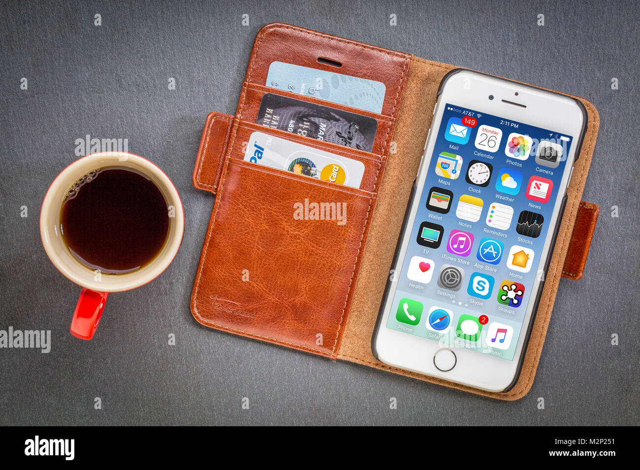 FORT COLLINS, CO, États-Unis d'Amérique - 1 janvier 2017 : l'iPhone 7 smart phone par Apple Computer Inc dans une pochette en cuir avec des cartes de crédit et du café contre le bac en pierre Banque D'Images