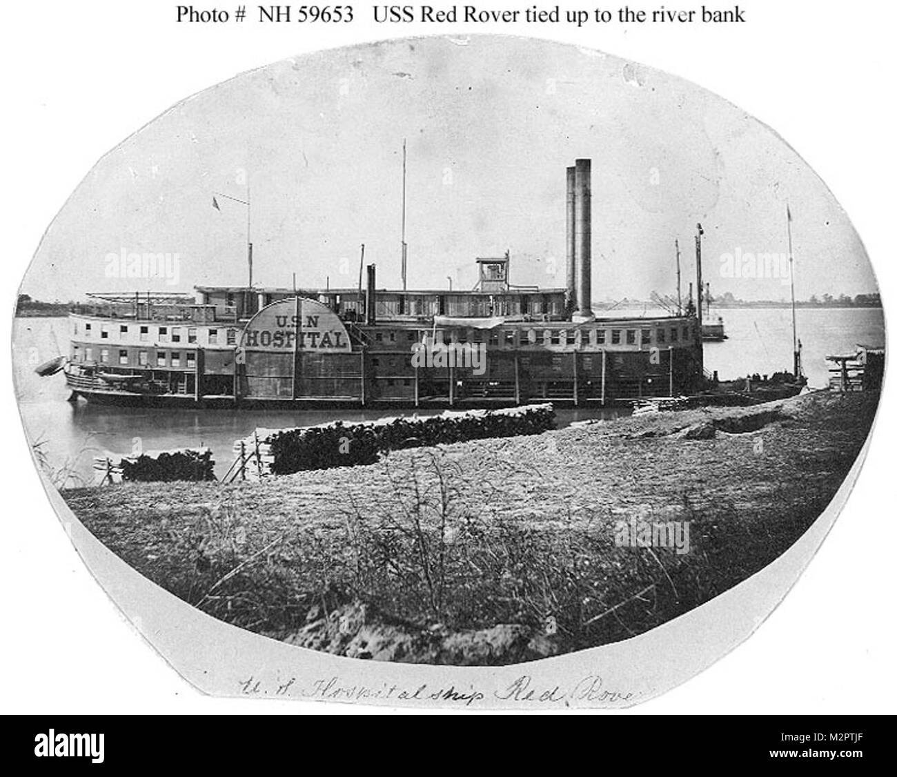 USS Red Rover (1862-1865) photographié attaché jusqu'à la rive sur l'ouest de l'eau pendant la guerre civile. Le bois est empilé dans l'avant-plan. USS Red Rover, une 625 tonnes à côté de la rivière de roue, bateau à vapeur a été construit pour un usage commercial à Cape Girardeau, Missouri, en 1859. Elle a servi comme CSS Red Rover en 1861-1862 et a été capturée le 7 avril 1862 l'île au numéro dix par USS Mound City. Après des réparations, il a été mis en service en tant que navire-hôpital pour l'ouest de l'armée américaine en juin 1862 Flottille de la canonnière. Elle a servi dans ce rôle grâce à l'été de 1862, et a été acheté par la Marine à la fin de Septembe Banque D'Images