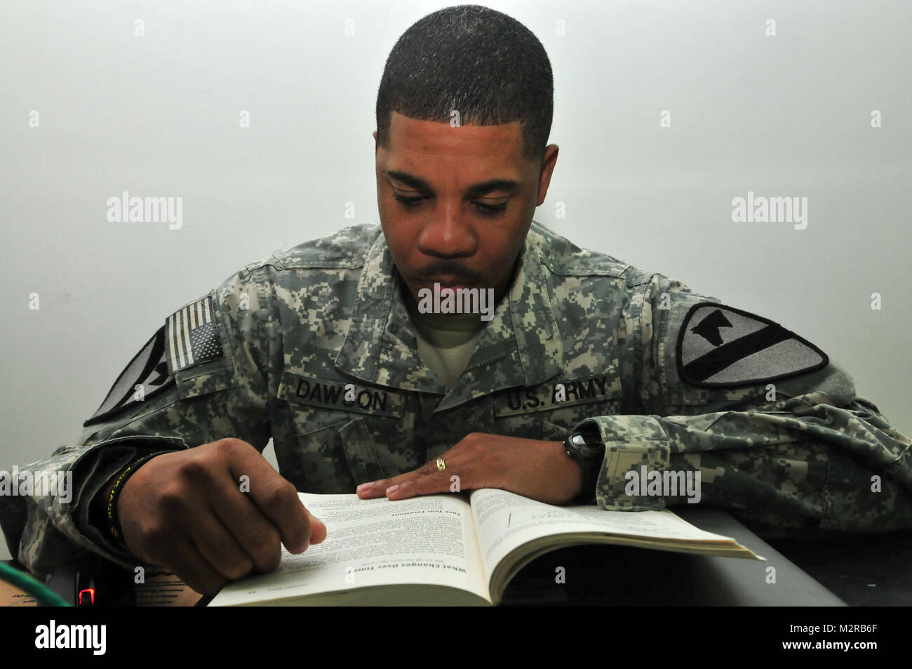 Le Sgt. 1re classe James Dawson, un natif de Houston et le conseiller de l'égalité des chances pour la 2e Brigade Combat Team (conseiller et d'aider), 1re Division de cavalerie, lit un manuel tout en mission au Camp Buehring, le Koweït, le 30 octobre. Dawson dit cours en ligne l'ont aidé à continuer ses études l'éducation tout au long de ses cinq déploiements. Un soldat lit un manuel d'opérations de déploiement par United States Forces - Iraq (inactif) Banque D'Images