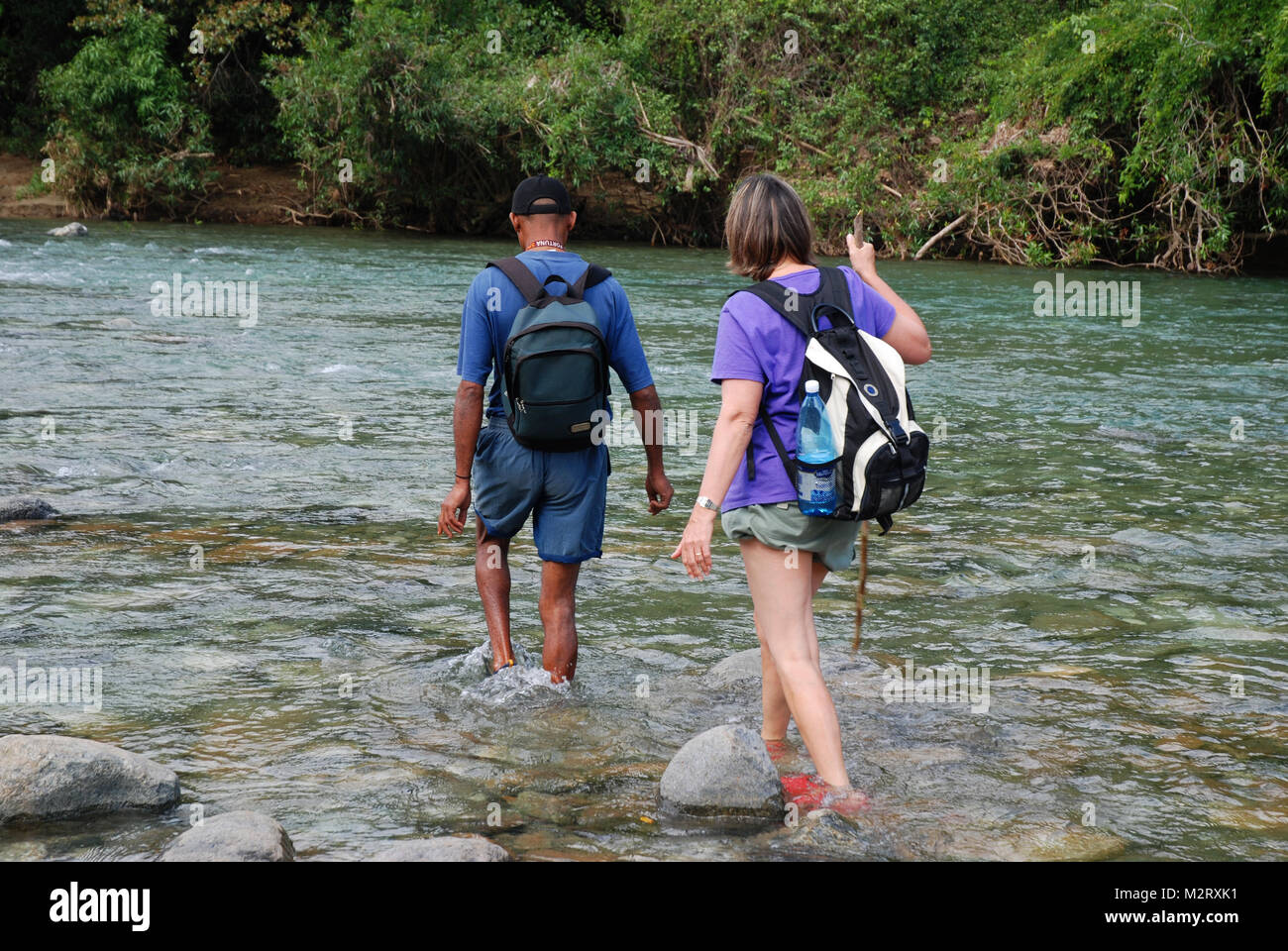 Et touristiques tourguide crossing river à pied dans le parc national El Yunque Baracoa, Cuba, Banque D'Images