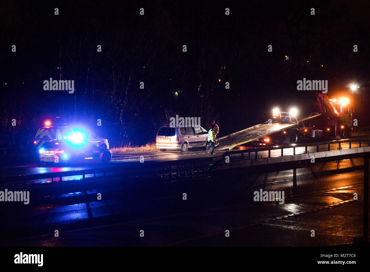 Dernier véhicule d'un véhicule sur la crasse A55 en cours de récupération de nuit avec la police et des services d'urgence présente, Flintshire, Pays de Galles, Royaume-Uni Banque D'Images