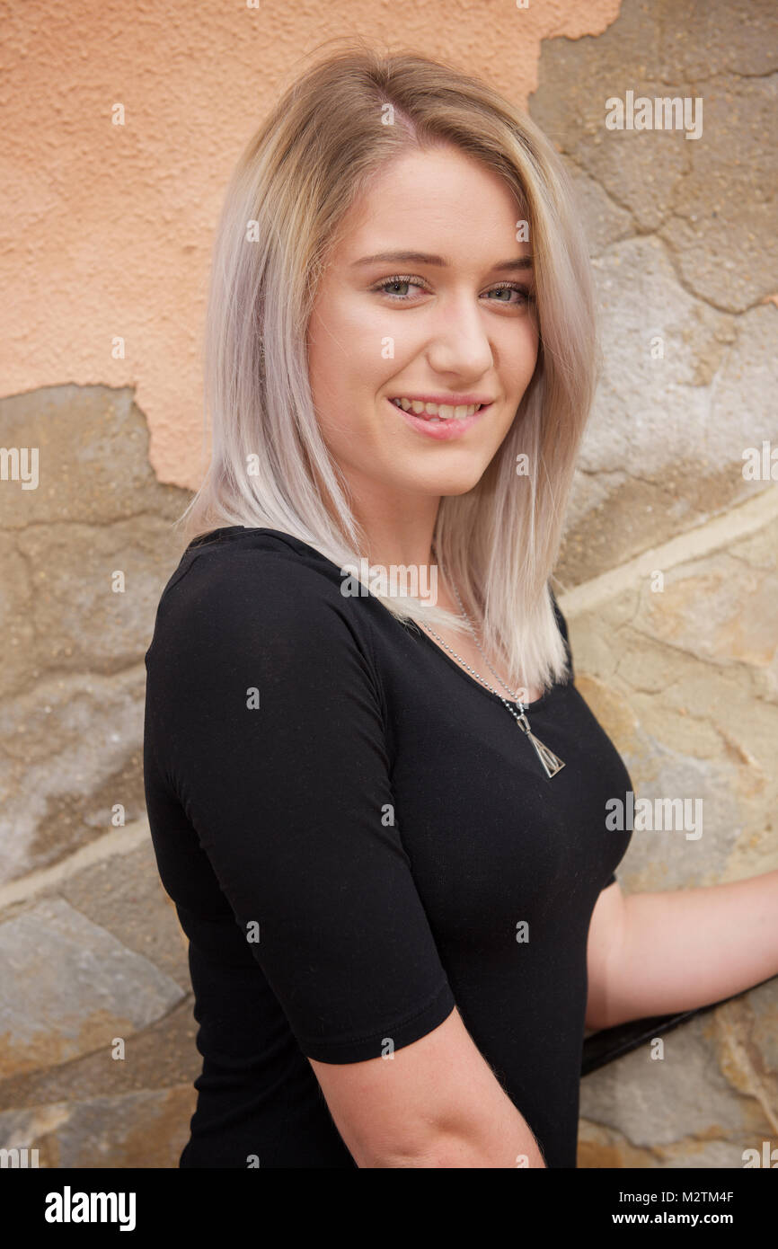 Belle fille blonde portant des jeans serrés et un t-shirt noir à  l'extérieur Photo Stock - Alamy