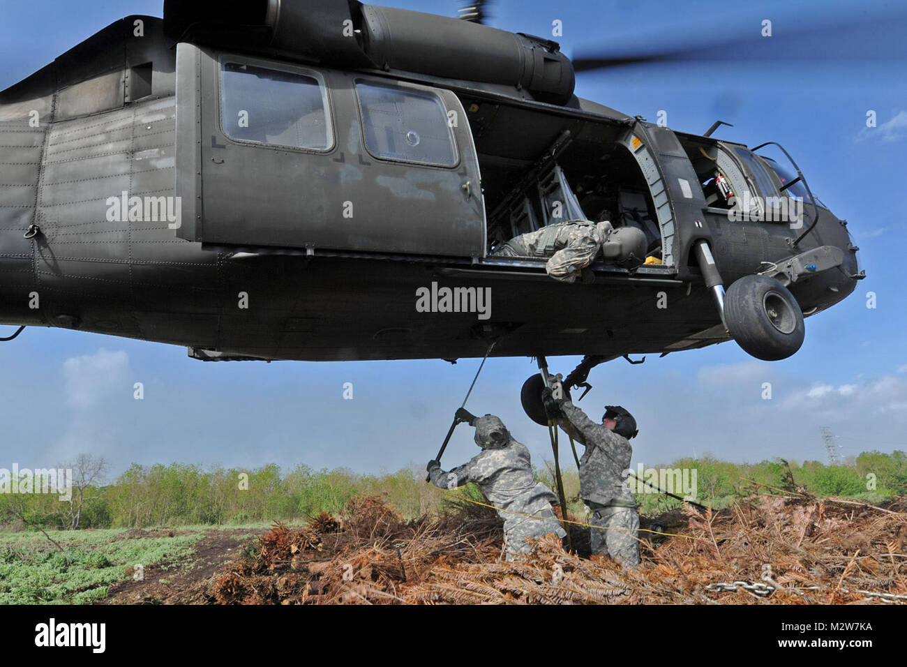 La Nouvelle Orléans - chefs d'équipage la garde nationale de la Louisiane à accrocher les élingues d'arbres de Noël à l'UH-60 Black Hawk du 1er Bataillon, 244th Aviation Regiment, à tomber dans l'Bayou Sauvage National Wildlife Refuge pour aider à reconstruire les zones humides, le 13 mars 2012, à la Nouvelle Orléans. Les arbres de Noël aide pour reconstruire les zones humides qui ont été emportés par les vagues au fil du temps et la collecte de limon la nouvelle végétation à prendre racine. (U.S. Air Force photo par le Sgt. M. Toby Valadie la garde nationale de la Louisiane, le Bureau des affaires publiques de l'état/libérés) 120313-F-VU La Garde nationale de la Louisiane par198-397 Banque D'Images