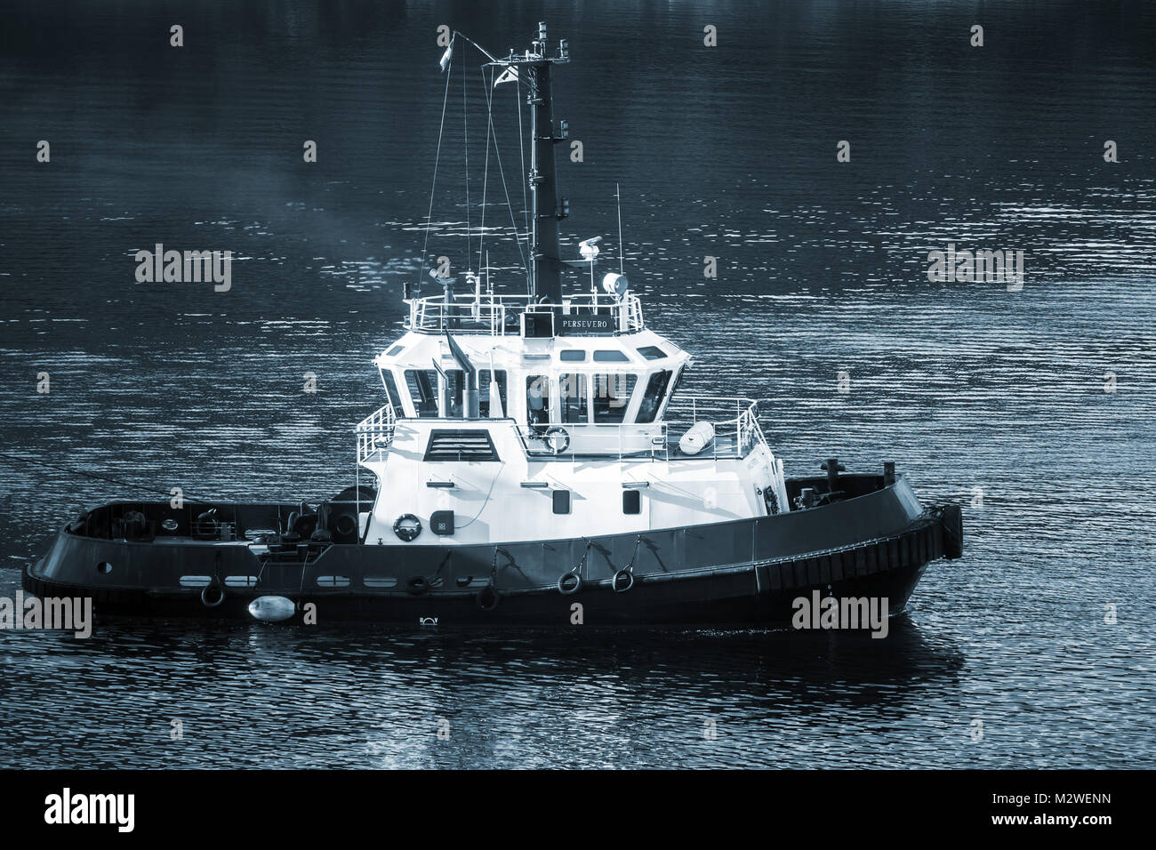 Corse, France - le 2 juillet 2015 : Reprendre tug boat en cours sur l'eau de mer. La baie de Porto Vecchio. Photo monochrome dans les tons bleus Banque D'Images