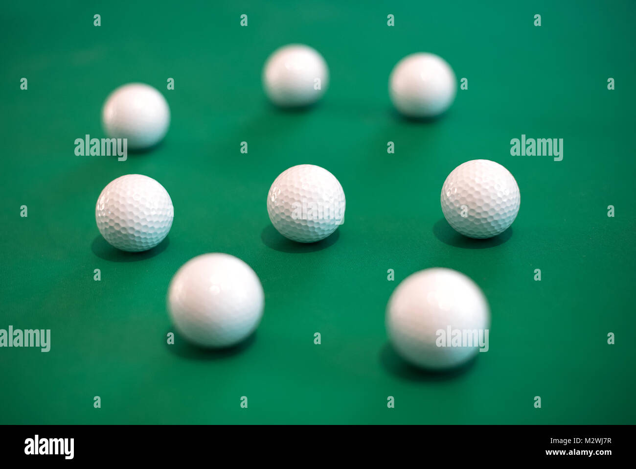 Huit balles de golf avoir menti sur fond vert Banque D'Images