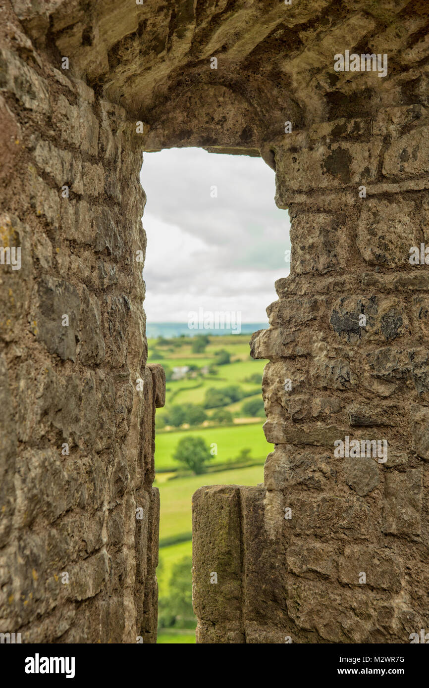 Voir à travers le trou dans le mur du château médiéval sur paysage environnant au Pays de Galles Banque D'Images