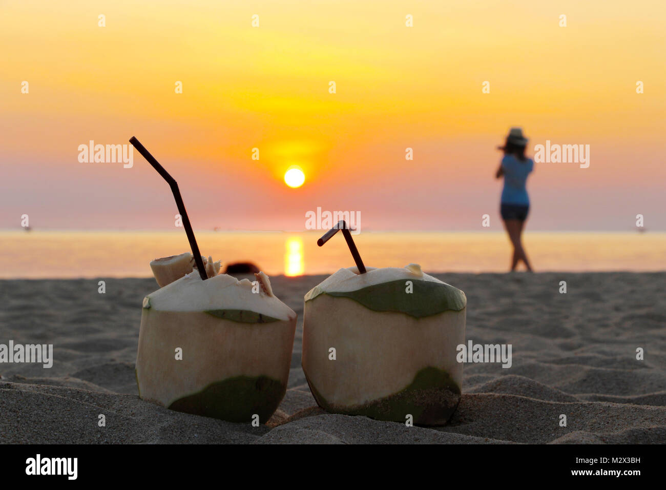 Pomme fruit cocktail sur la plage et une femme jouit de la coucher du soleil Banque D'Images