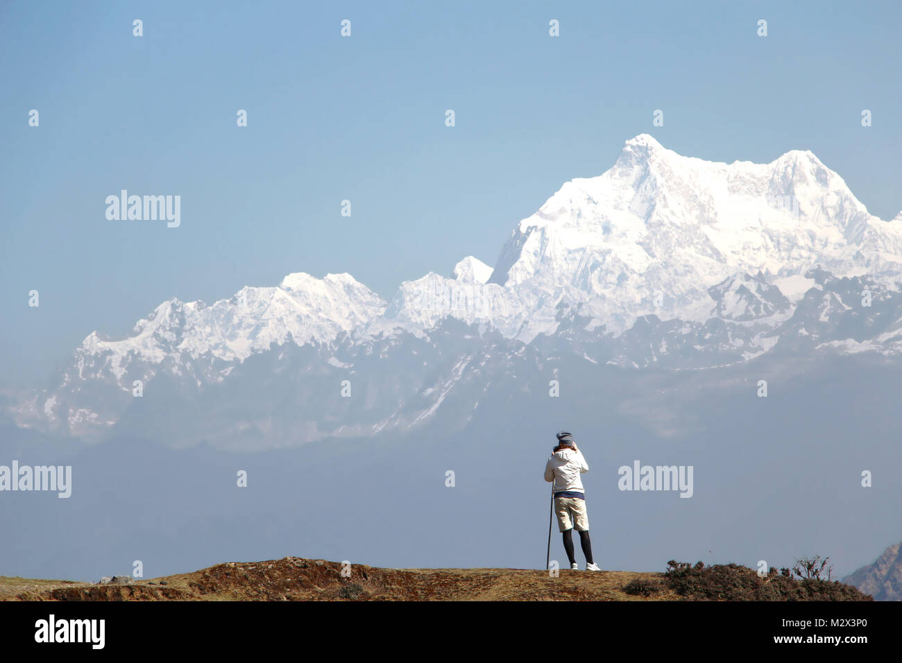 Randonneur jouit de magnifiques vues panoramiques sur de hautes montagnes avec de la neige Banque D'Images