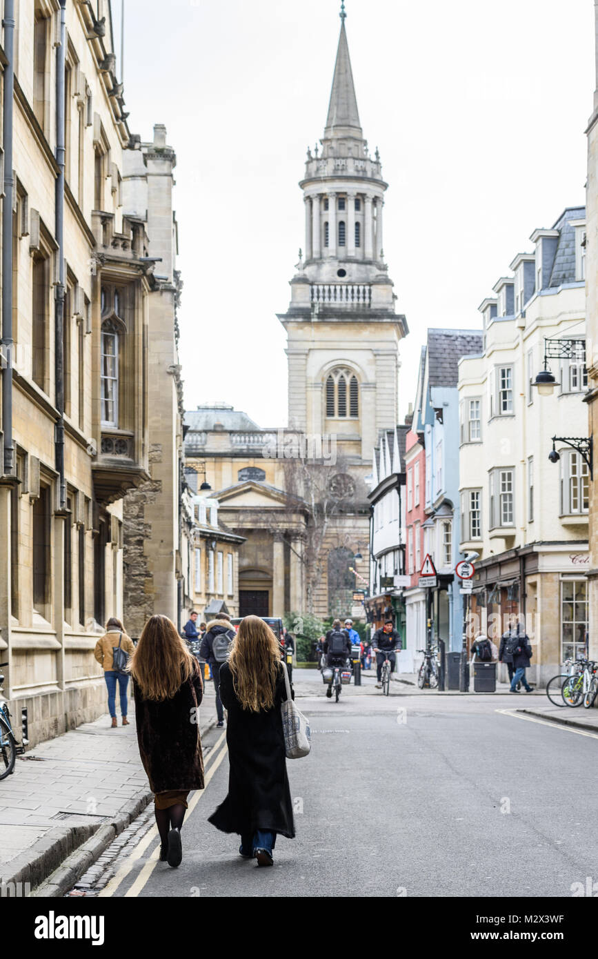 Deux femmes à pied à l'unisson et côte à côte le long de la rue croupe Cours des collèges de l'université dans la ville d'Oxford, en Angleterre. Banque D'Images