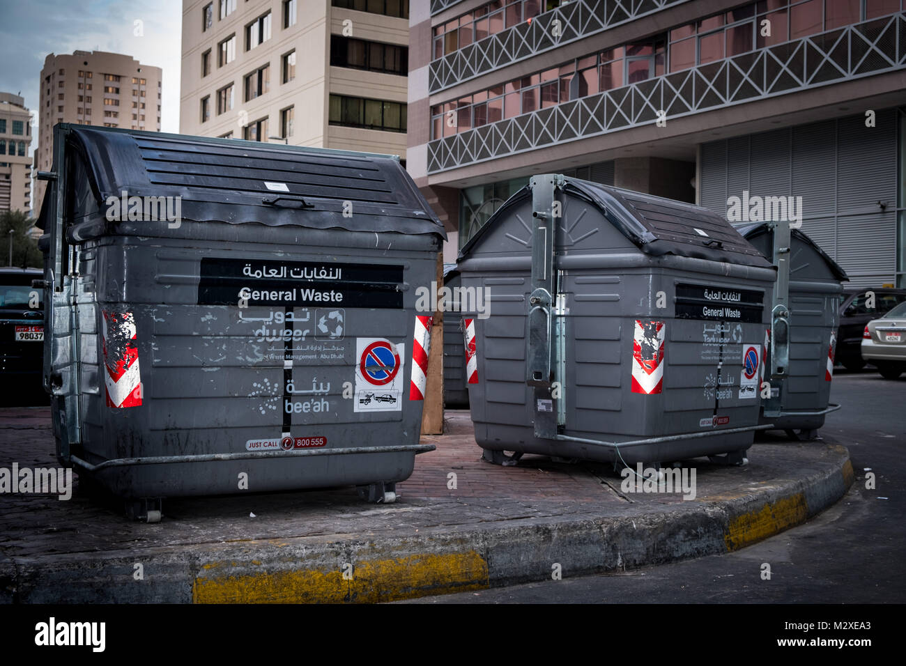 De grandes poubelles placées près des appartements dans une ville Banque D'Images