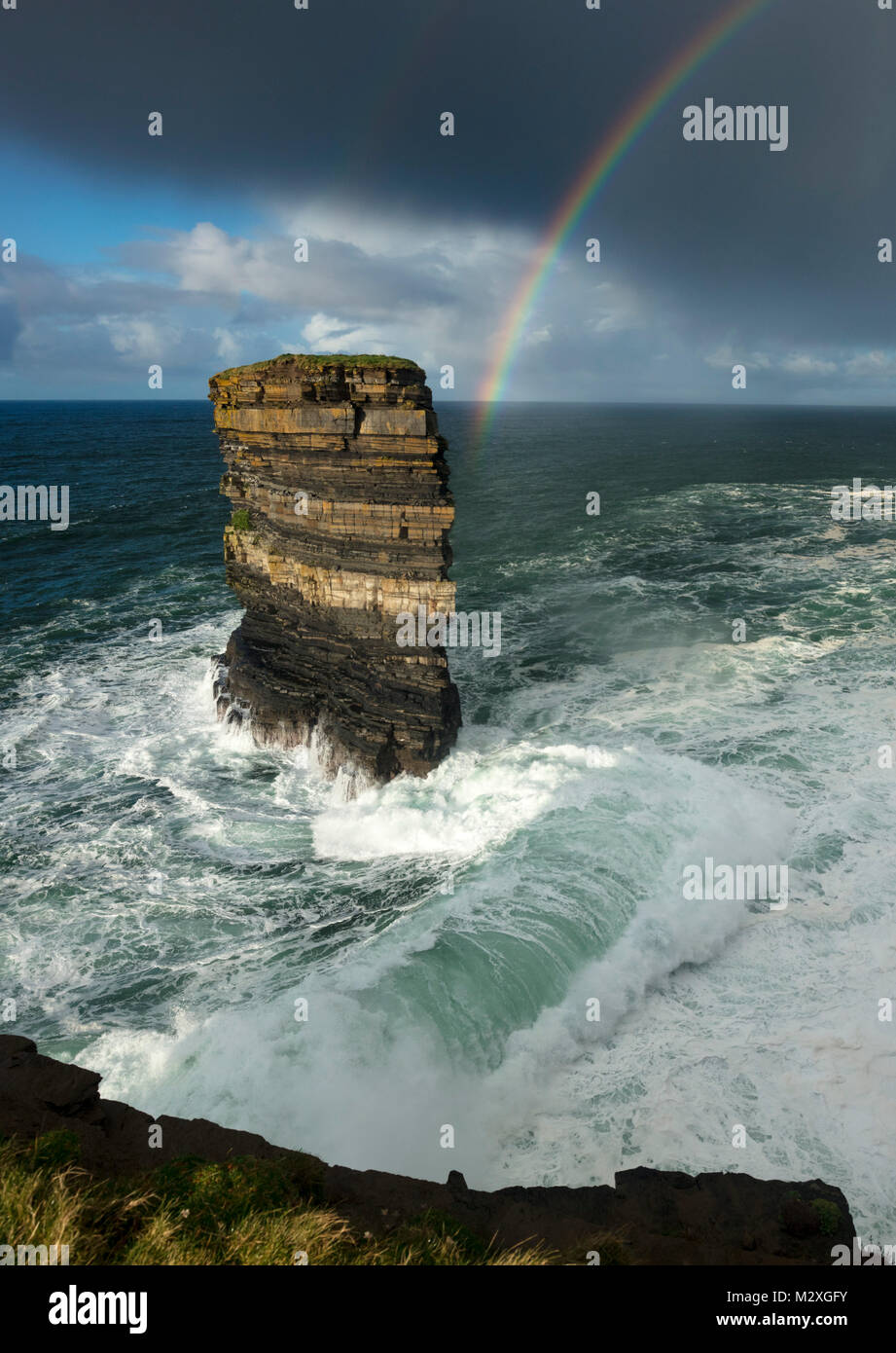 Arc-en-ciel et les vagues de tempête, seastack surround Dun Briste Downpatrick Head, dans le comté de Mayo, Irlande. Banque D'Images
