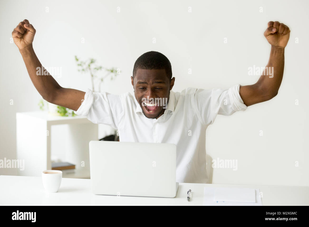 Heureux gagnant de l'Afrique de l'euphorie à la célébration de l'ordinateur  portable à gagner en ligne réalisation succès conséquent, homme noir  heureux bonne nouvelle, motivé par le gre Photo Stock - Alamy