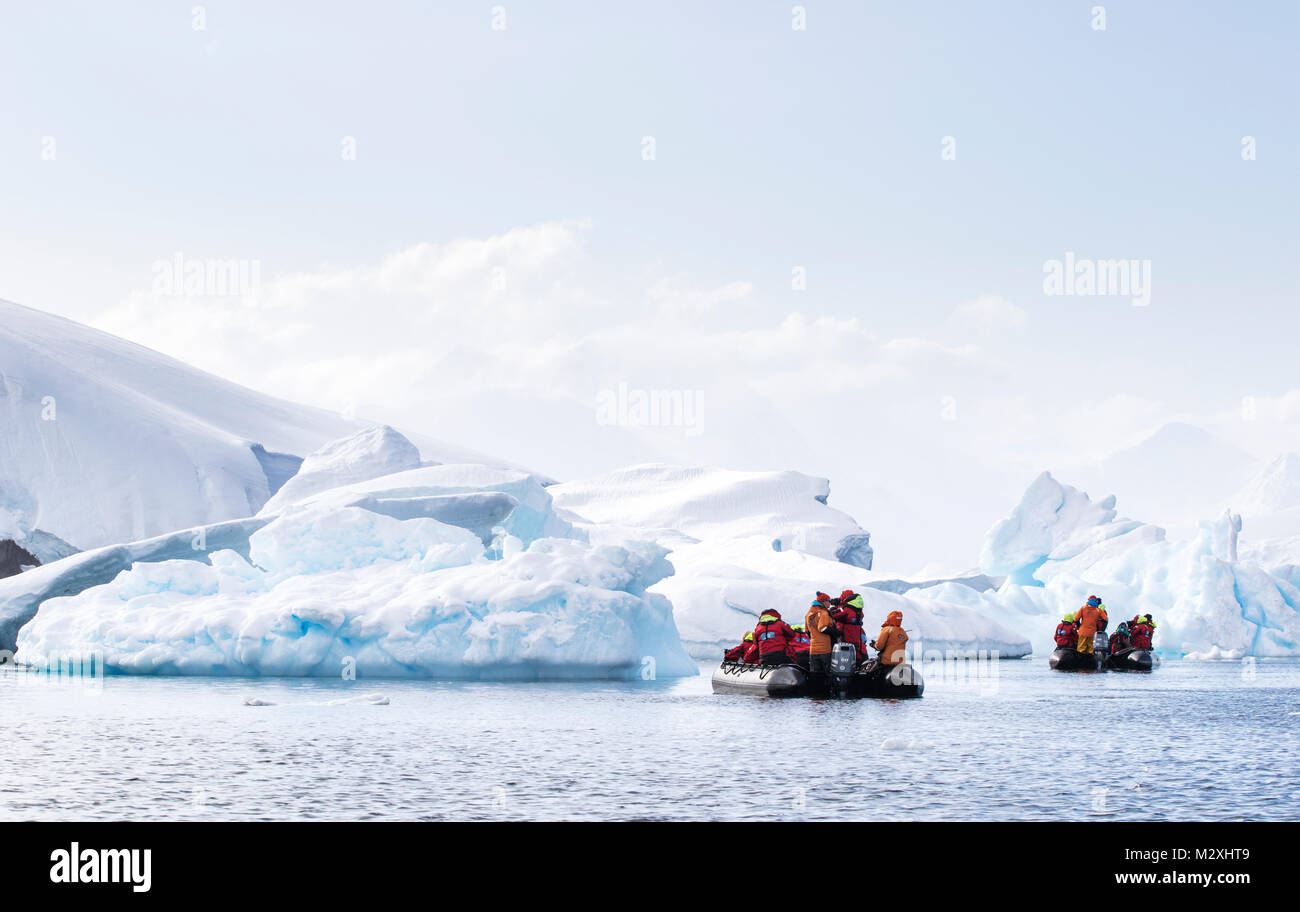Un groupe de touristes sur une croisière zodiac parmi les icebergs de Whilemina Bay, l'Antarctique. Banque D'Images