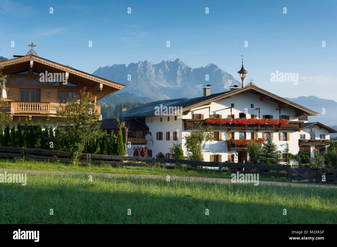 Autriche, Tyrol, Reith bei Kitzbuehel, ferme avec beffroi, maisons en construction traditionnelle, dans l'arrière-plan les montagnes Kaiser Banque D'Images