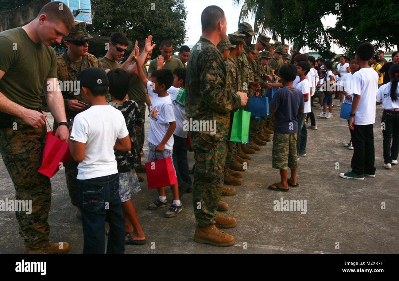 Enfants philippins de l'Orphelinat de Bahay Nanay ni recevoir des sacs de fournitures scolaires donnés par les Marines américains et les marins à Antonio Bautista sur la base aérienne de Puerto Princesa, Palawan, Philippines, le 21 avril 2012. Les enfants et les soldats ont passé plusieurs heures ensemble se connaître et jouer à des jeux. Les membres du service sont en ce moment ici pour la durée de Balikatan 2012 et sont une partie de la Force opérationnelle de Palawan. BK12 est un accord bilatéral, l'exercice conjoint effectué chaque année entre les États-Unis et la République des Philippines. Cette année marque le 28ème itération de la nat Banque D'Images