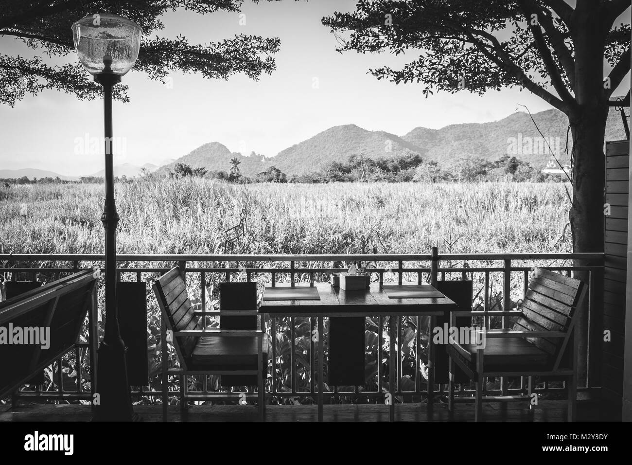 Abstract image en noir et blanc table à manger en bois et une chaise dans un restaurant avec vue sur la magnifique arrière-plan naturak. Banque D'Images