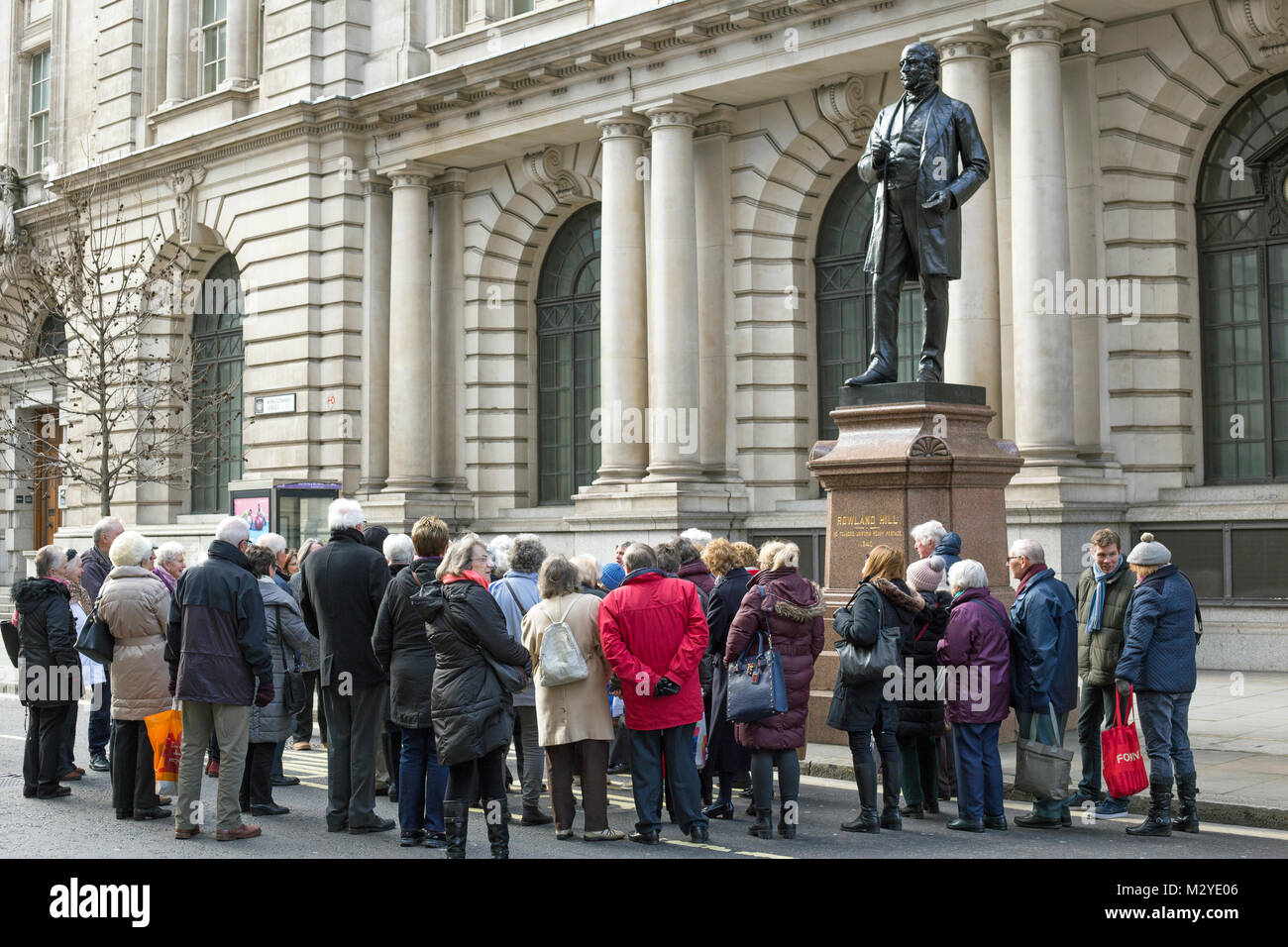 Londres, Angleterre, février 2018, un groupe se réunit autour d'une statue de Rowland Hill. Banque D'Images