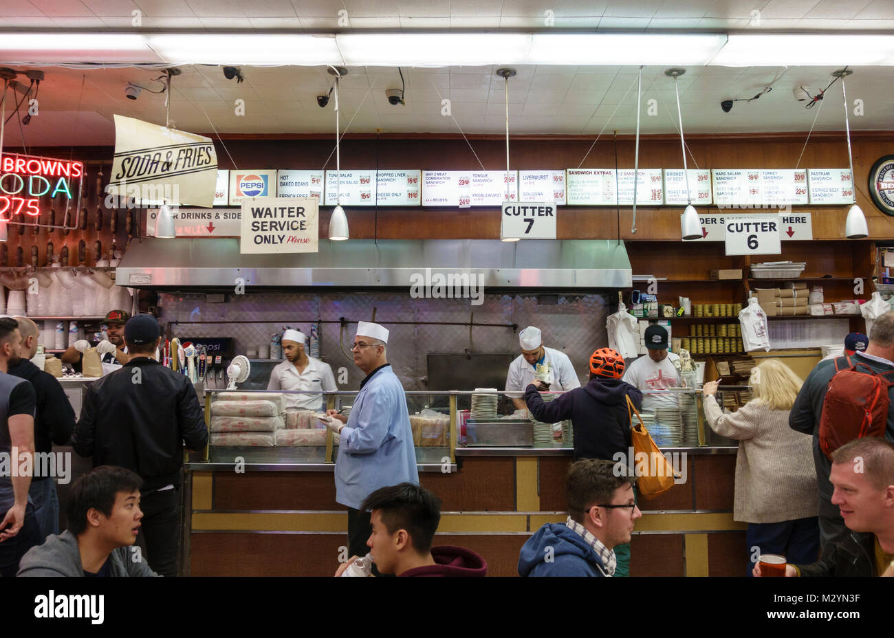 Les clients, les serveurs et le personnel de cuisine au guichet au Katz's Delicatessen, un célèbre New York City Restaurant deli juif. Banque D'Images