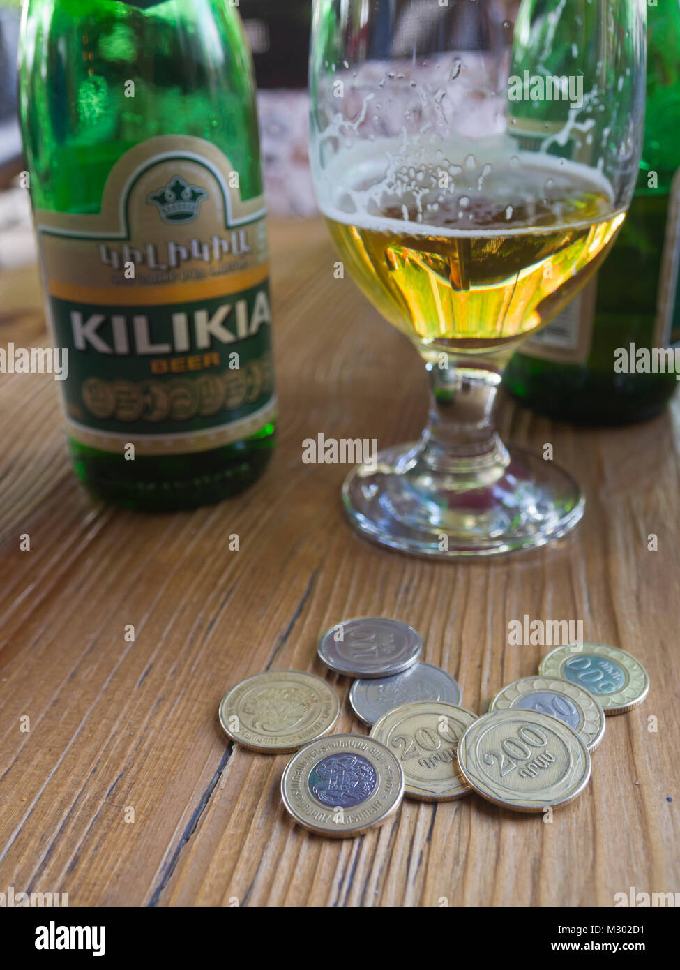 Bière Kilikia arménienne dans une bouteille et un verre, monnaies locales, dram, sur la table dans un restaurant à Erevan, Arménie Banque D'Images
