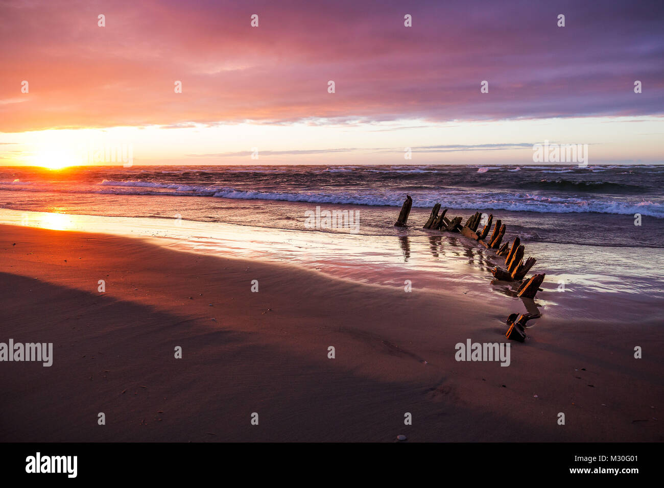 La plage à Hirtshals, Danemark au coucher du soleil avec une vieille épave Banque D'Images