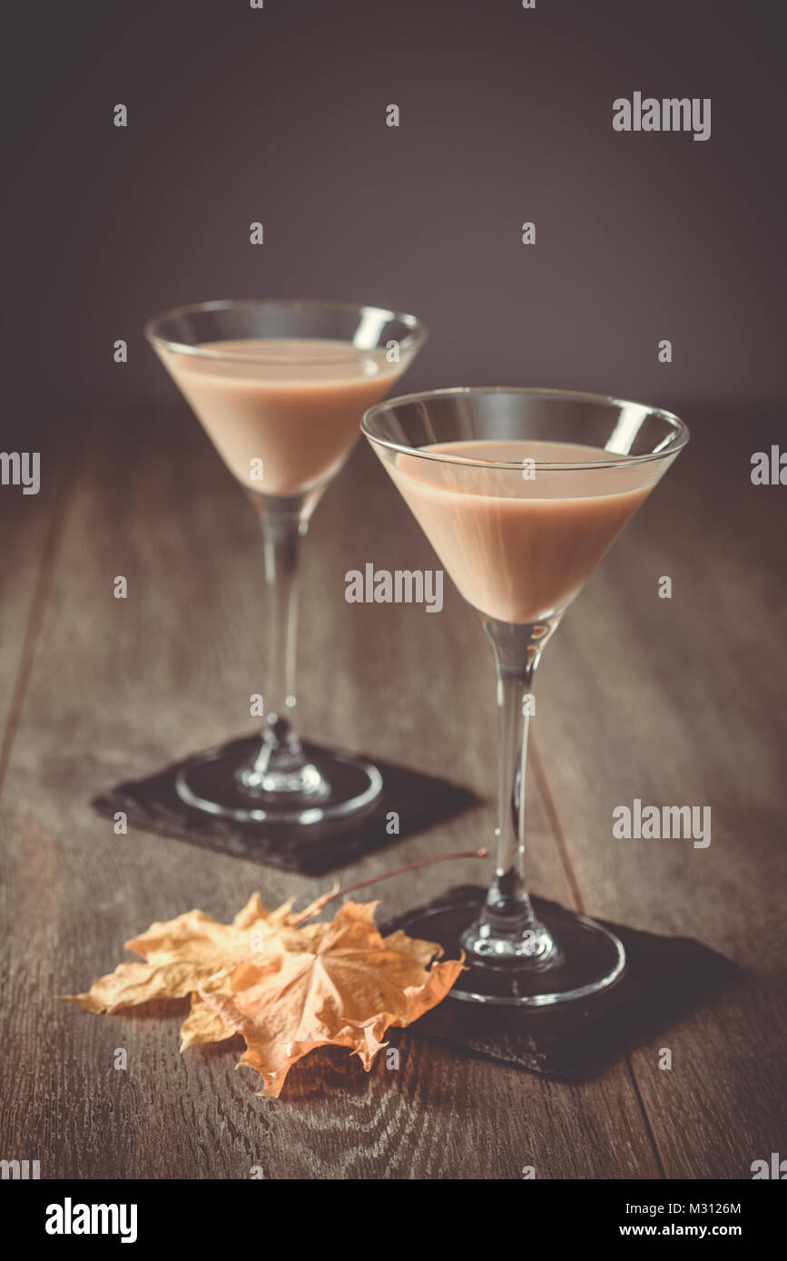 Deux Irish Cream liqueurs sur ardoise sous-verres avec les feuilles d'automne Banque D'Images