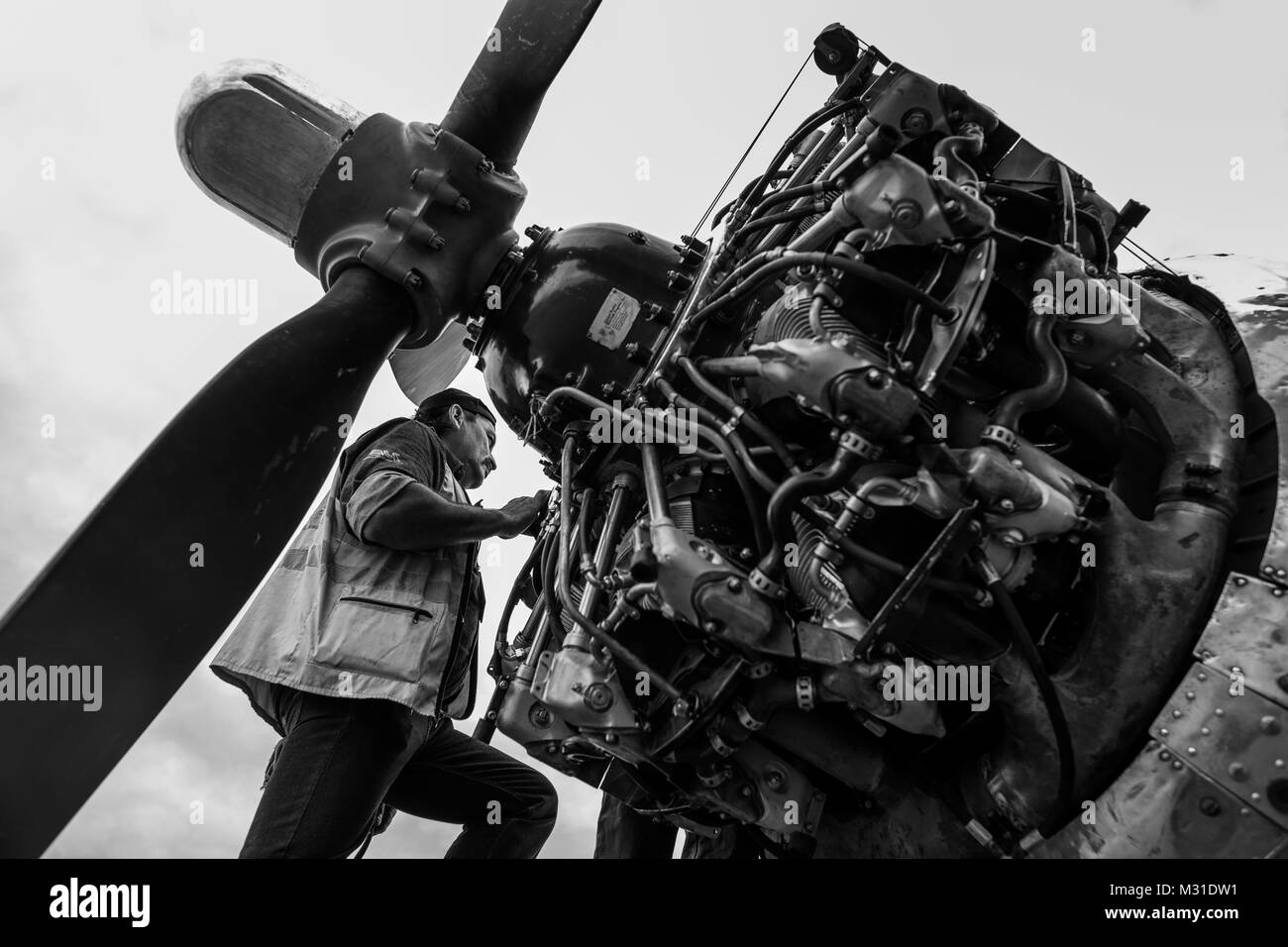 Un mécanicien colombien fonctionne sur un moteur radial au cours d'une vérification de maintenance de routine d'un Douglas DC-3 à l'aéroport de Villavicencio, Colombie. Banque D'Images