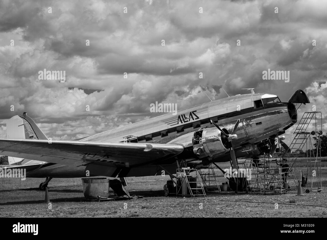 Mécanique colombien effectuer une vérification de l'entretien de routine d'un Douglas DC-3 à l'extérieur du hangar à l'aéroport de Villavicencio, Colombie. Banque D'Images
