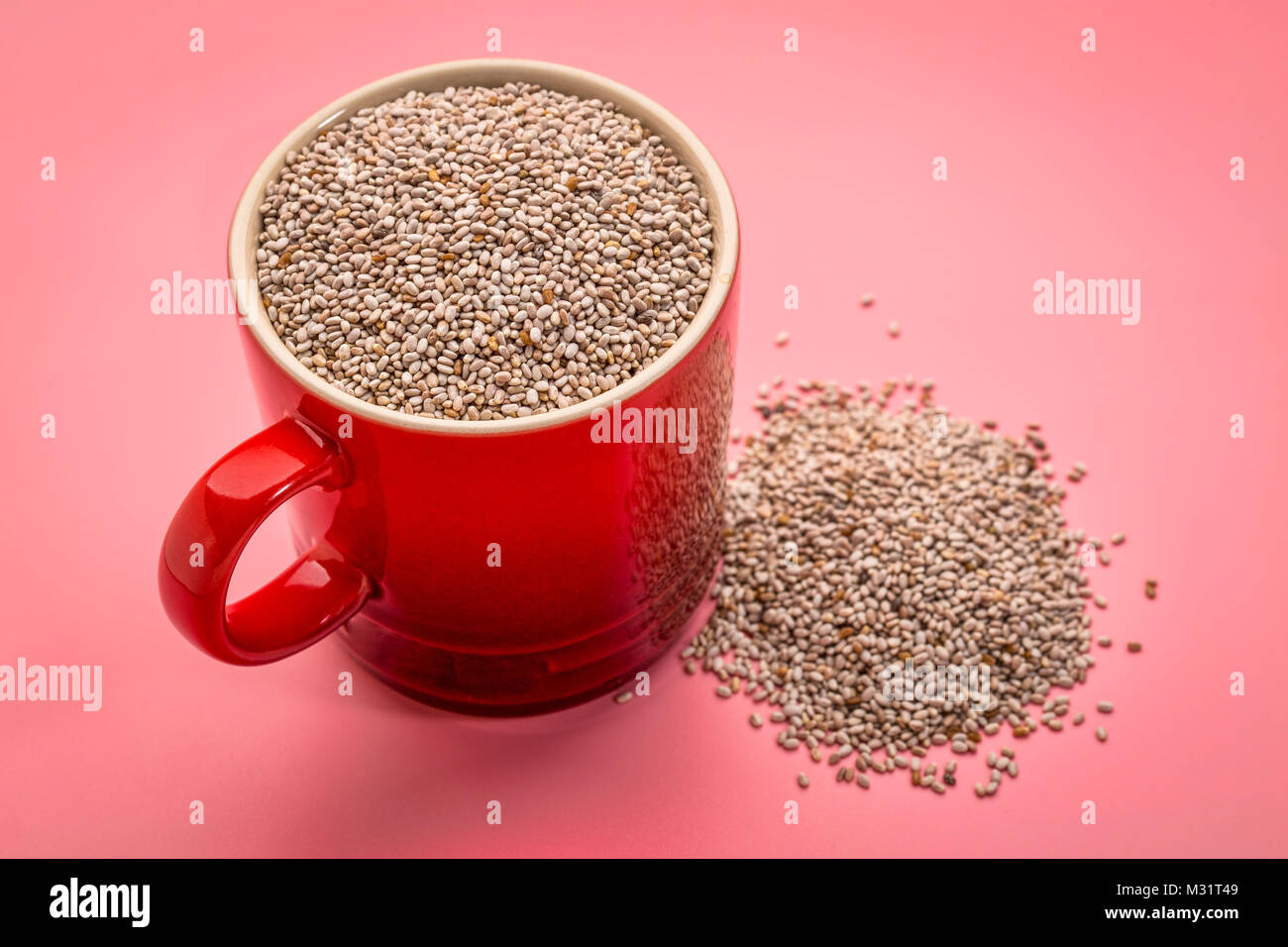 Une petite tasse de café chia blanc biologique graines riches en acides gras omega-3 contre fond rose Banque D'Images