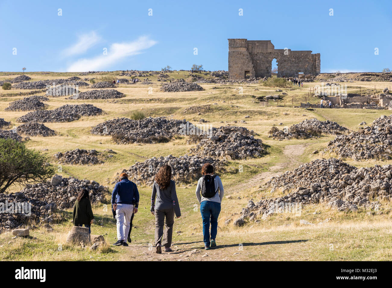 Les gens à marcher vers le théâtre romain d'Acinipo, partie du site archéologique de l'ancienne ville d'Acinipo dans la Serrania de Ronda, Province Banque D'Images