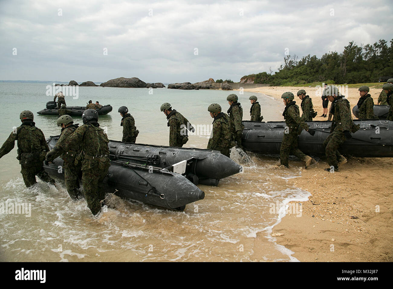 Les membres du Service avec le Japon d'autodéfense au sol en caoutchouc pour tirer la lutte contre le maraudage dans l'eau, à Kin Bleu, Okinawa, Japon, Mars 1. La JGSDF ont observé les Marines du 3e Bataillon de Reconnaissance, 3e Division de marines, III Marine Expeditionary Force, la pratique du scoutisme et techniques nageur raid conduite des missions. La JGSDF membres sont avec 43e Régiment d'infanterie. (U.S. Photo par le Cpl Marine. Robert Williams Jr./libérés) Japonais et les forces américaines s'entraînent ensemble à Okinawa par # PACOM Banque D'Images