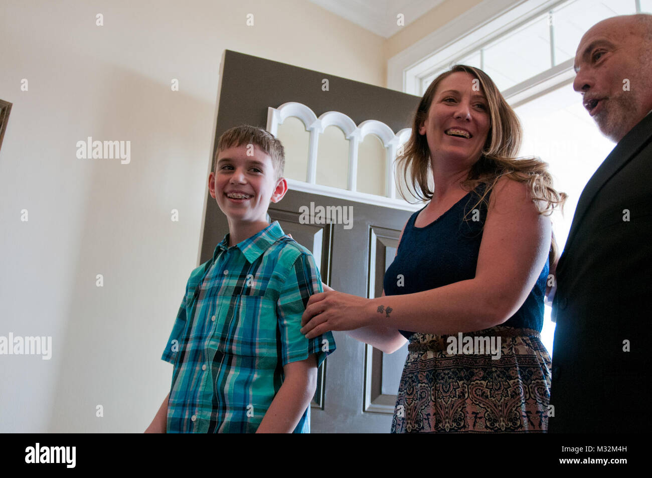 Le s.. Michelle Satterfield, avec le 14e Détachement de quartier-maître, centre, et son fils, Hunter, gauche, marcher dans leur nouvelle maison pour la première fois au cours de sa cérémonie à McKeesport, Pennsylvanie, le 25 avril 2016. Satterfield reçoit une maison construite par les étudiants de l'McKeesport Area High School et Stephen Siller Tunnel à la base de tous les tours du travail bénévole qu'elle a accompli au cours des dernières années. (U.S. Photo de l'armée par le sergent. Dalton Smith / Relâché) Le s.. Michelle Satterfield reçoit de nouvelles home par 316E ESC Banque D'Images