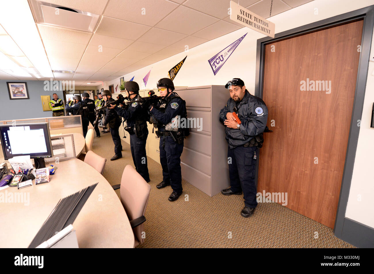 L'agent de sécurité du camp Mabry Jimmy John, droit, ainsi que des membres de la Police d'Austin's Counter Strike Team Assualt (CAST), espaces de travail sécurisé à un tireur actif scénario de formation s'est déroulée au Camp Mabry à Austin, Texas, le 19 mars 2014. Les agents de sécurité du camp et d'employés formés avec le CAST de répéter des scénarios de tireurs actifs afin de mieux se préparer à cet événement. (U.S. La Garde nationale de l'armée photo par le Sgt. 1re classe Malcolm McClendon). 140319-Z-FG822-003 par Texas Département militaire Banque D'Images