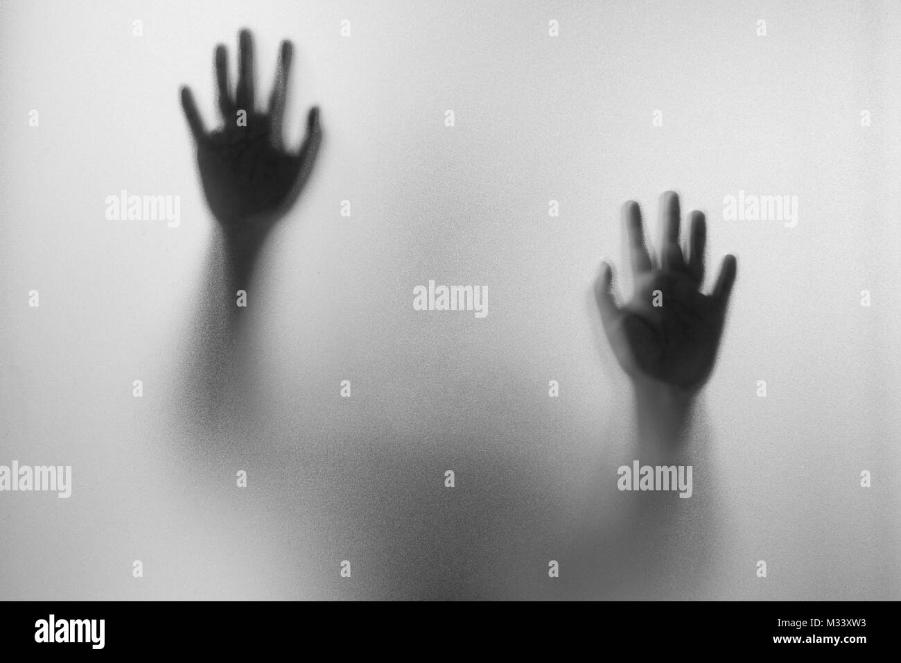 Les mains de l'ombre de l'homme derrière le verre dépoli.main.Halloween abstraction floue.fond noir et blanc photo Banque D'Images