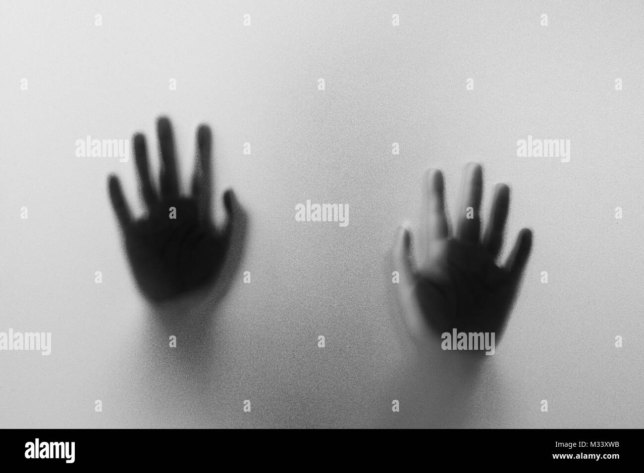 Les mains de l'ombre de l'homme derrière le verre dépoli.main.Halloween abstraction floue.fond noir et blanc photo Banque D'Images