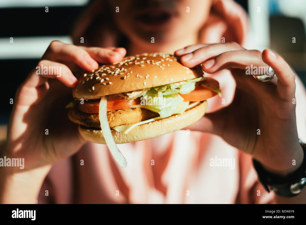 Femme mangeant un hamburger Banque D'Images