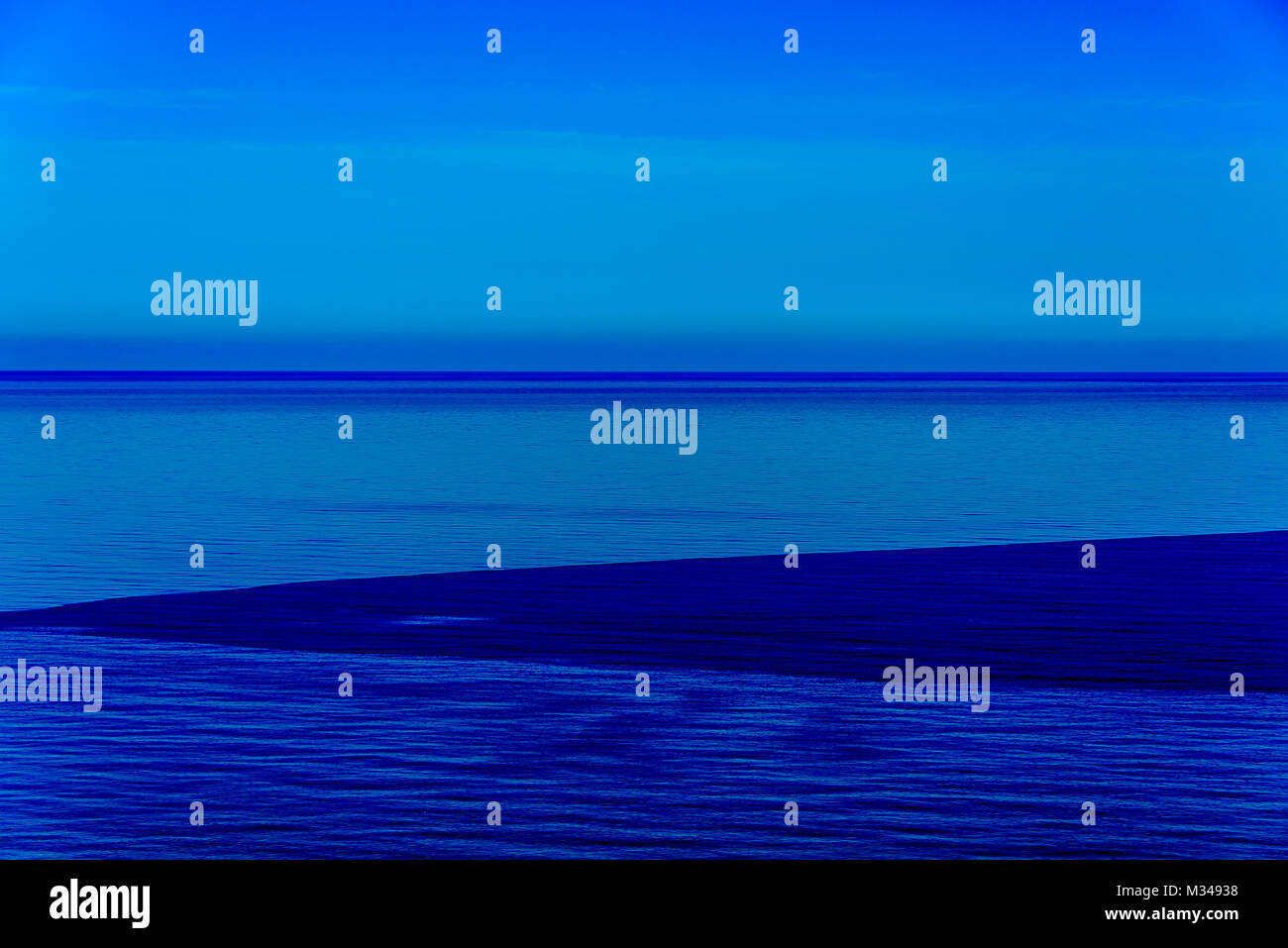 L'exposition longue stylisée sunset seascape avec différentes nuances de bleu présentée comme un résumé fine art photo. Banque D'Images