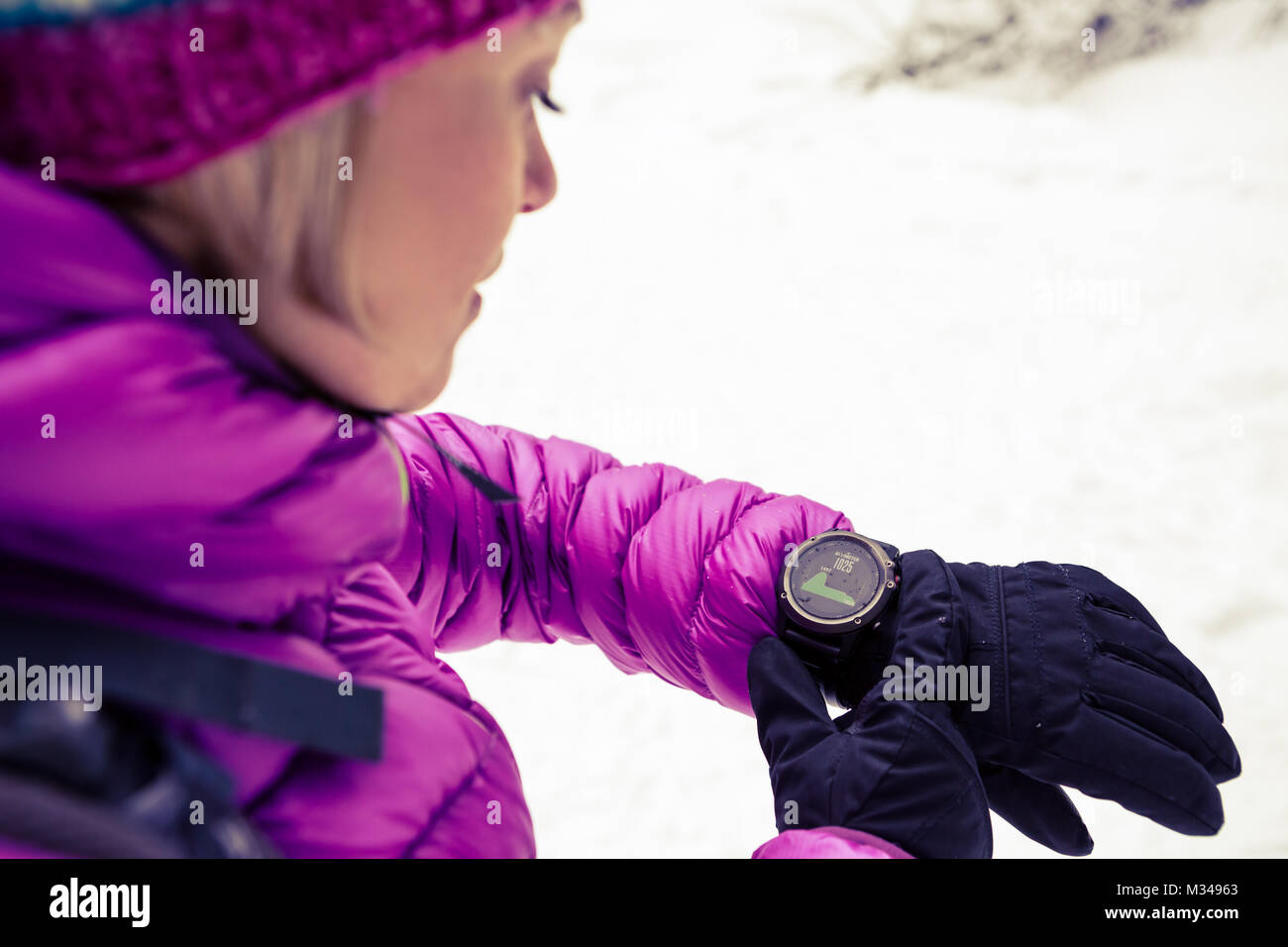 Contrôle de la femme sur l'élévation des randonneurs sports watch, smartwatch avec altimètre app en hiver bois et les montagnes. Trekker femelle blanche dans la forêt enneigée Banque D'Images