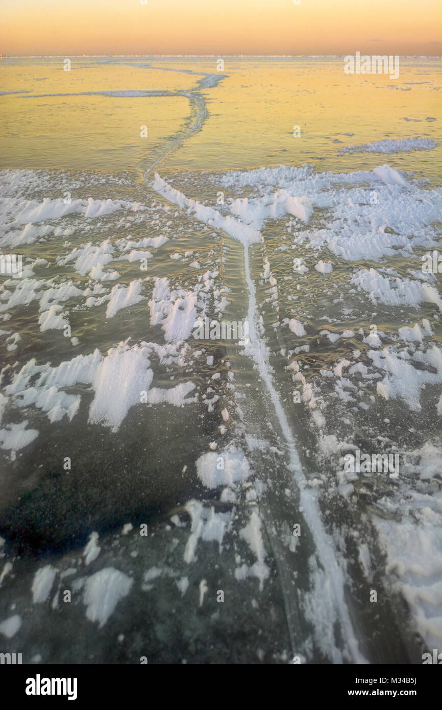 Limite de jeunes (nilas) et de vieille glace à la baie d'eau douce de la mer Baltique, faible soleil d'hiver en contour, première fissure dans la glace, les cristaux de glace Banque D'Images