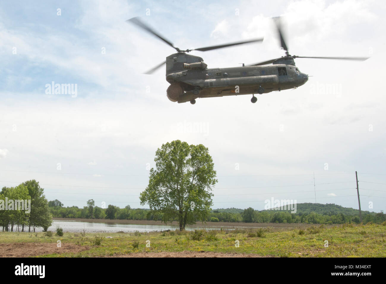 Un CH-47 Chinook', 'hélicoptère exploité par les membres de la société B, 2e Bataillon, 149e Bataillon de soutien de l'aviation générale, New Jersey Army National Guard, une chute de 1 200 livres à balles de foin sur une zone d'alimentation des bovins à Muskogee Comté. Plus de 100 vaches qui étaient bloqués par les inondations après de fortes pluies au cours de la semaine du Memorial Day ont été à l'aide de la région. L'équipage du Chinook livré plus de 14 000 livres de foin et 700 livres d'aliments pour animaux à l'animaux échoués au cours de l'état d'une journée mission service actif.PHOTO : Le Major Geoff Legler, Washington National Guard de foin d'affaires publiques 016 Drop par Oklahoma Banque D'Images