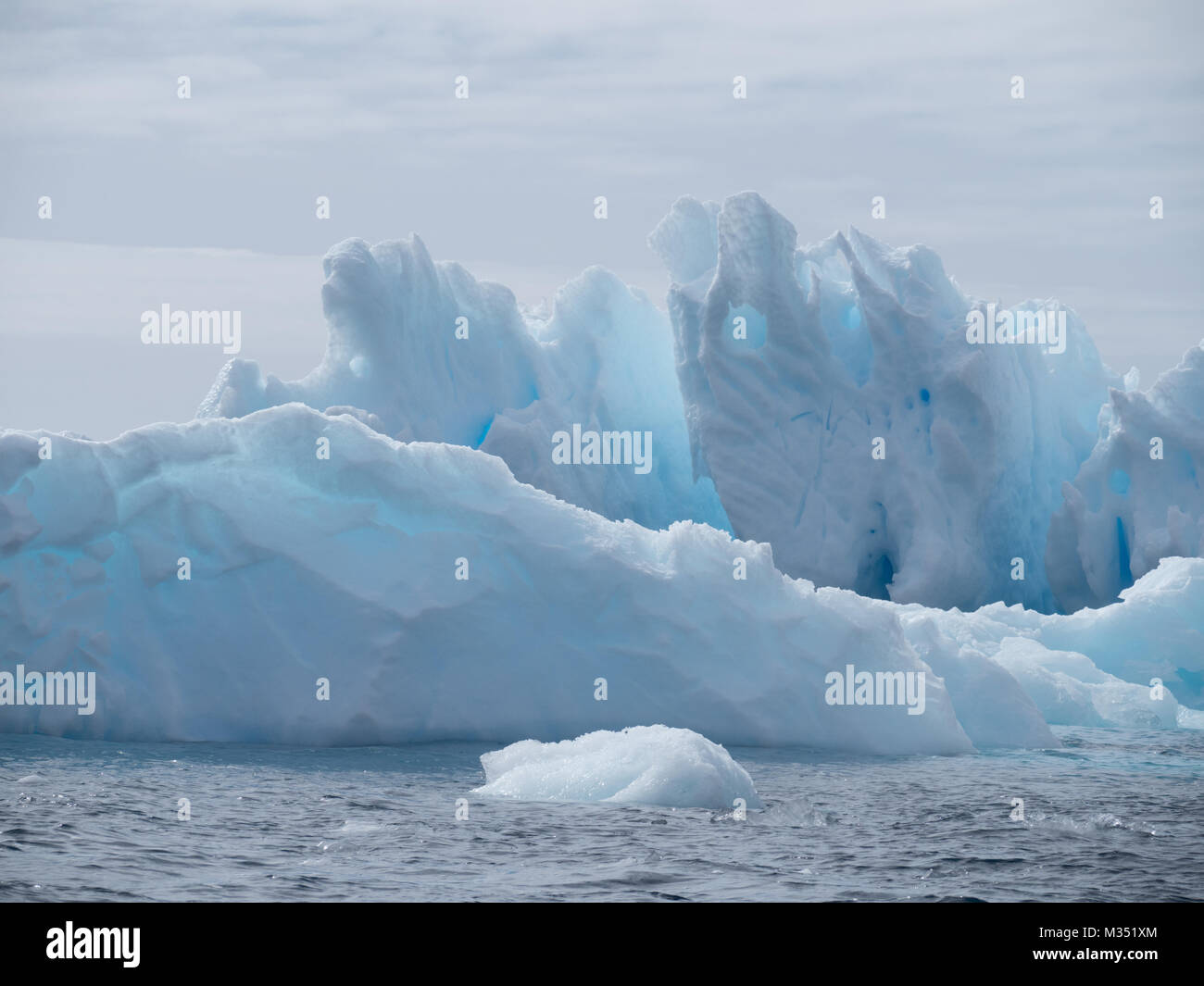 Les icebergs bleu texturé robuste, dansant dans l'océan qui entoure le continent antarctique. Banque D'Images