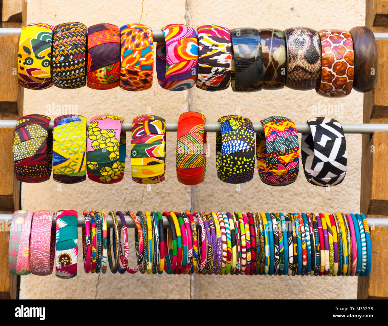 Close up de plusieurs couverts de tissu coloré, bangle bracelets sur un rack. Photographié en lumière naturelle au niveau de l'oeil. Banque D'Images