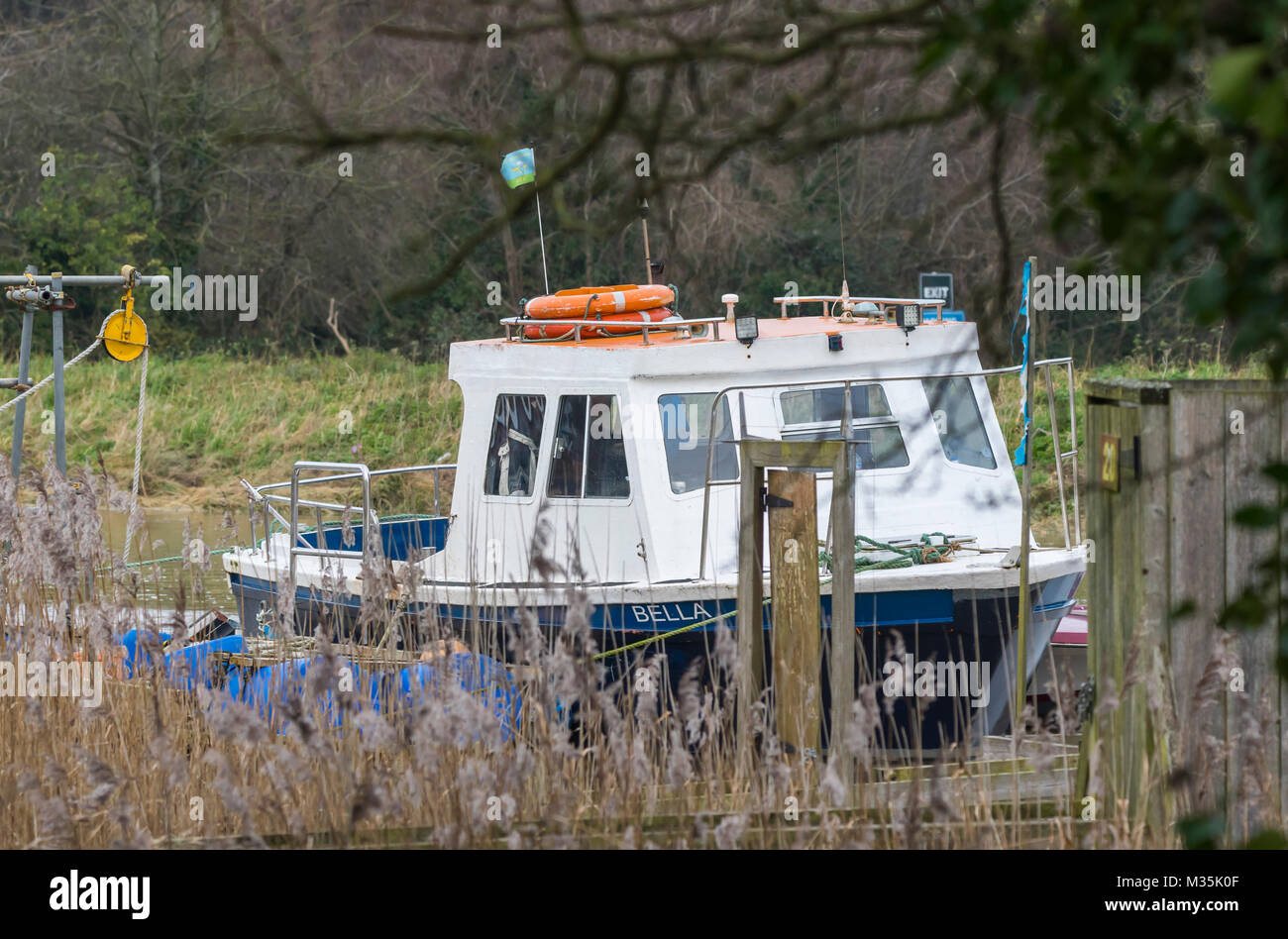 Petit bateau amarré sur une rivière en hiver en Angleterre, Royaume-Uni. Banque D'Images