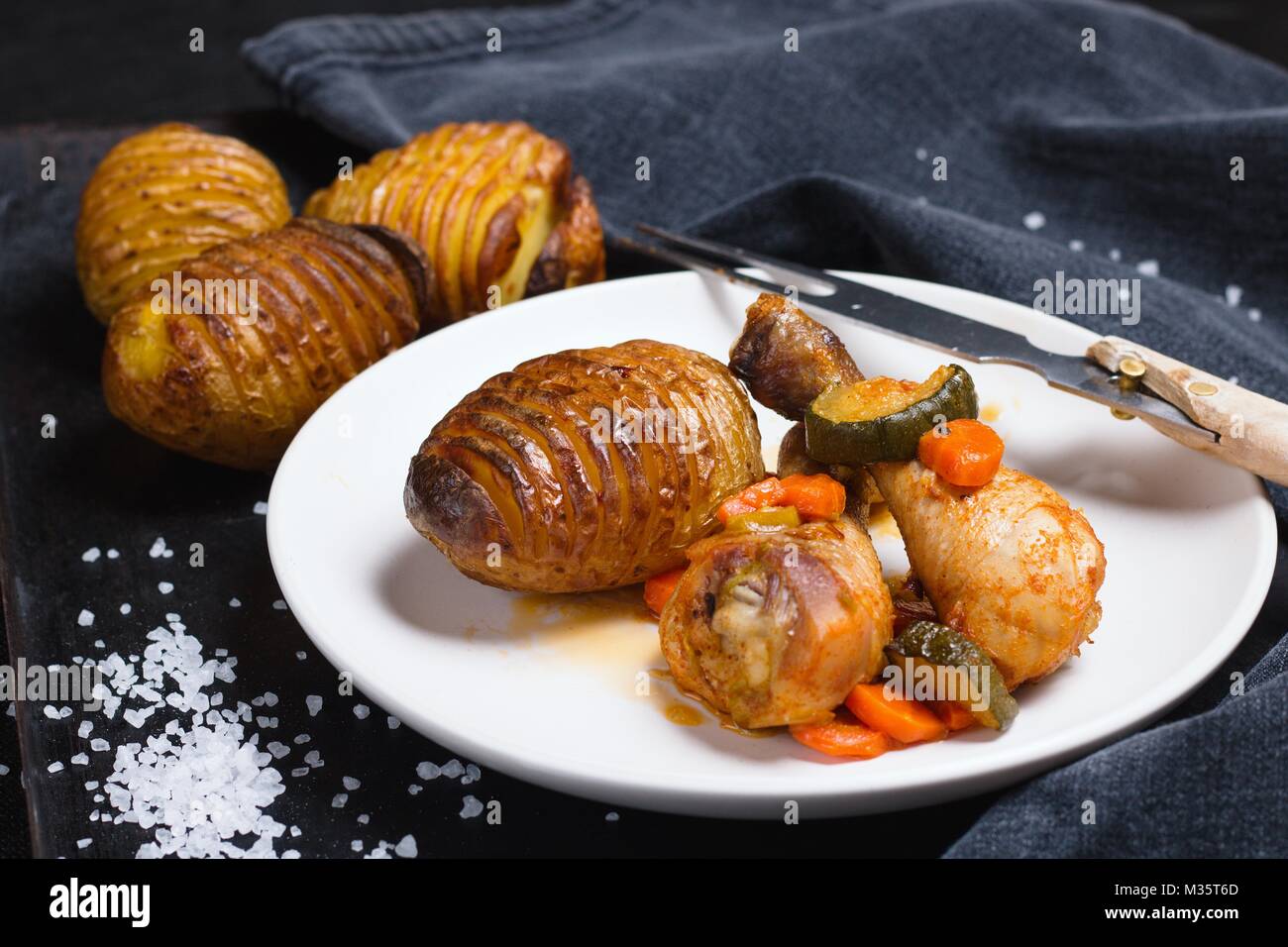 Pilons de poulet, rôti et pommes de terre hasselback avec comme