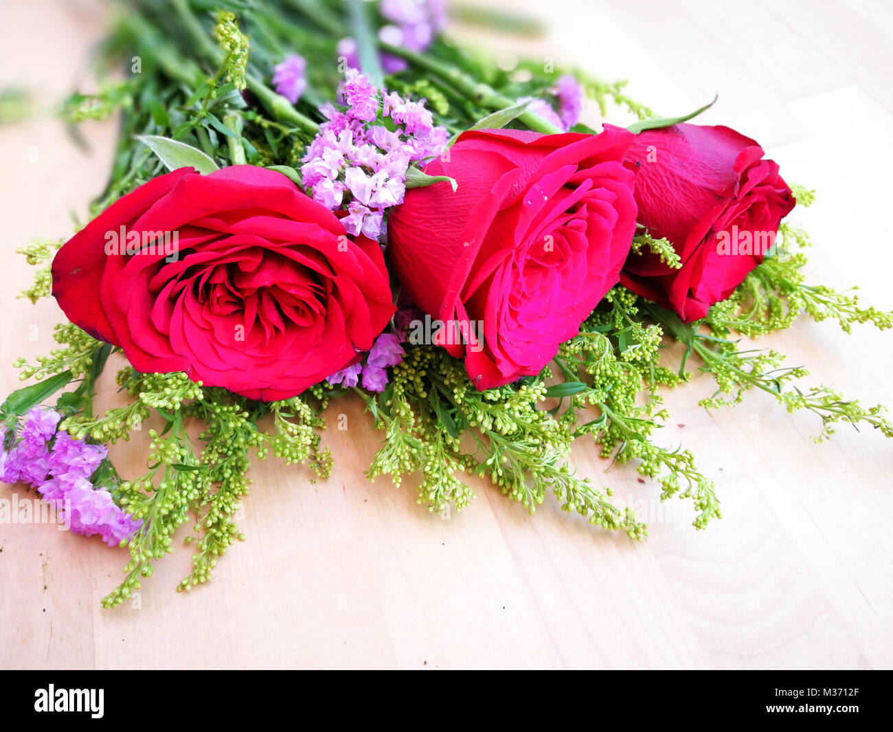 Bouquet de roses rouges sur fond de bois. Concept de la Saint-Valentin, anniversaire, fête des mères, l'amour, de soins et d'anniversaires. Banque D'Images