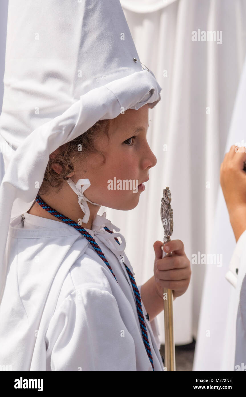 Fille pénitent de la confrérie de 'La Paz', avec le faux masque et un bâton de commandement dans la main. Banque D'Images